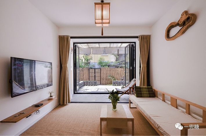 客厅的大折叠门打开后,客厅朝着院子敞开,努力向院子伸展,和庭院融为